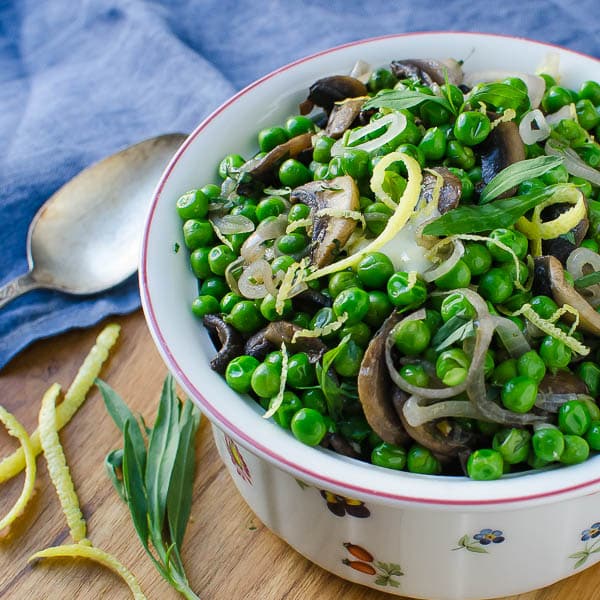 A side dish of peas and mushrooms in a bowl.