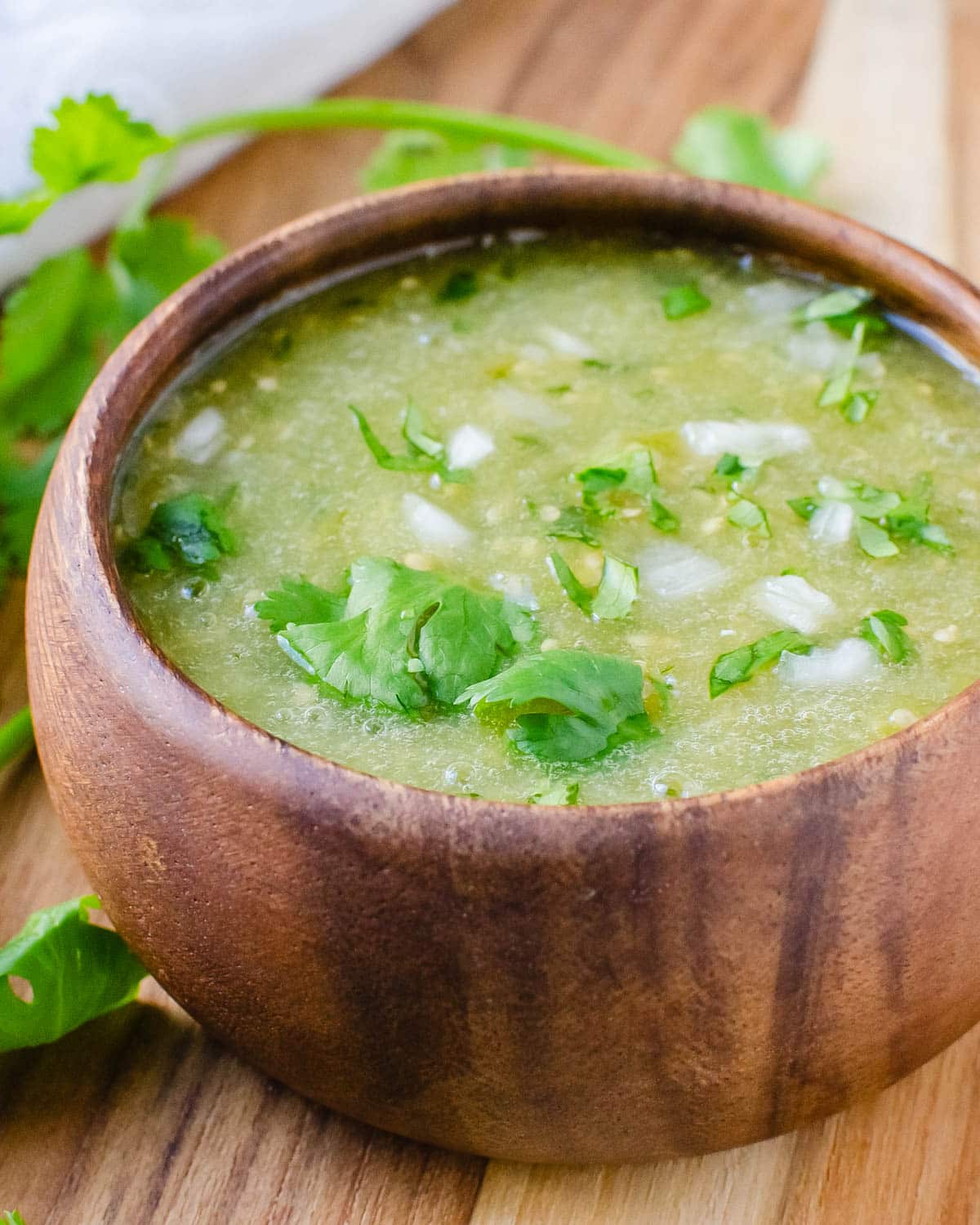 A bowl of salsa verde with onion and cilantro.
