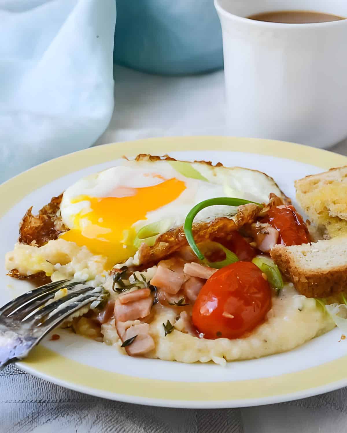 Breakfast stack with ham and tomatoes, grits and eggs.