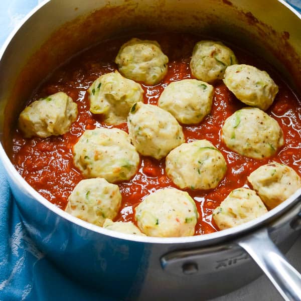 Adding meatballs to sauce.