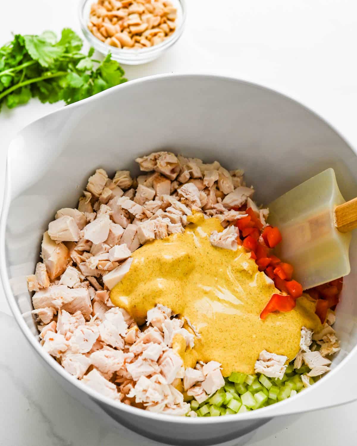 Adding curry dressing to the diced chicken 