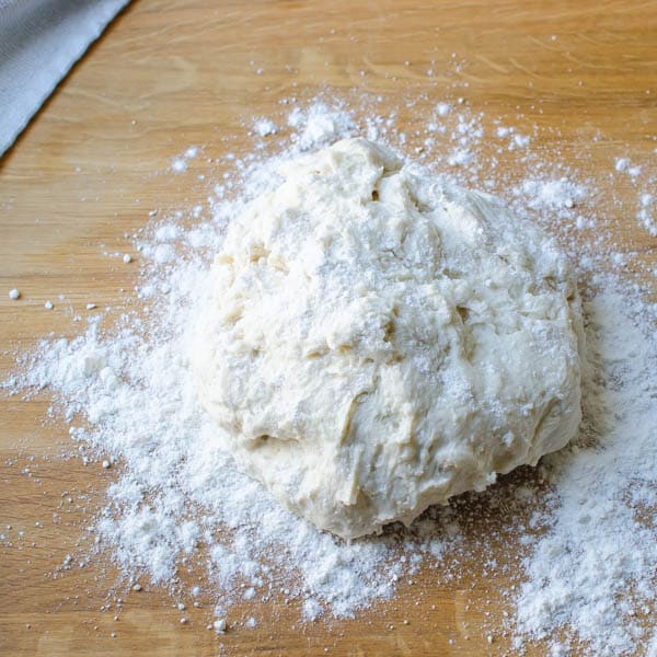 Dusting the dough with flour on a board.