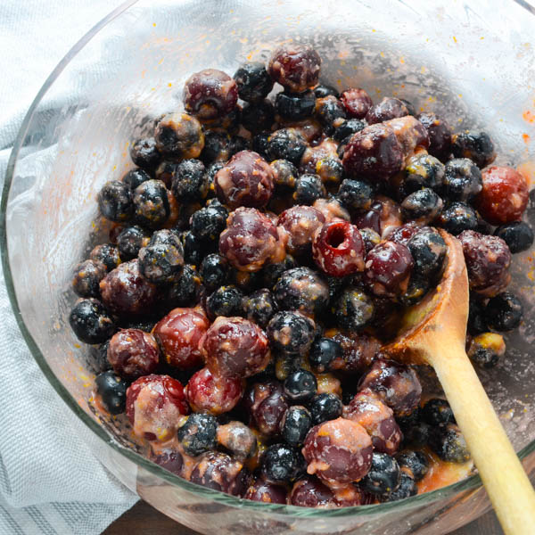 blueberries and cherries mixed with cornstarch in a bowl.