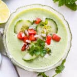 A bowl of chilled cucumber soup with pico de gallo garnish.