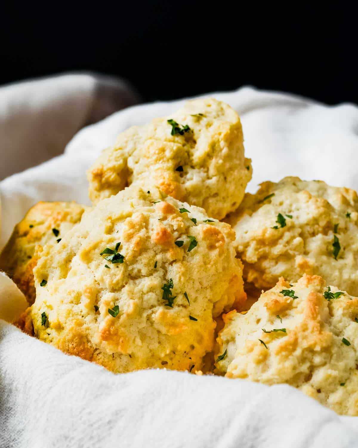 A bread basket filled with drop biscuits.
