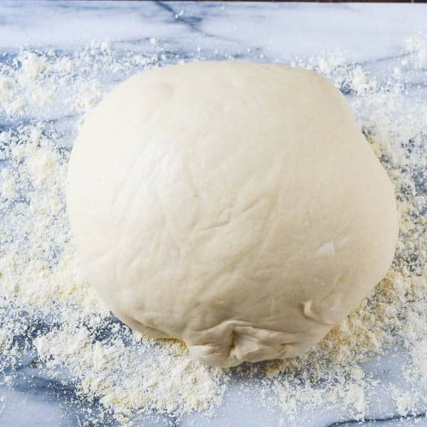 Pizza dough on a marble board.