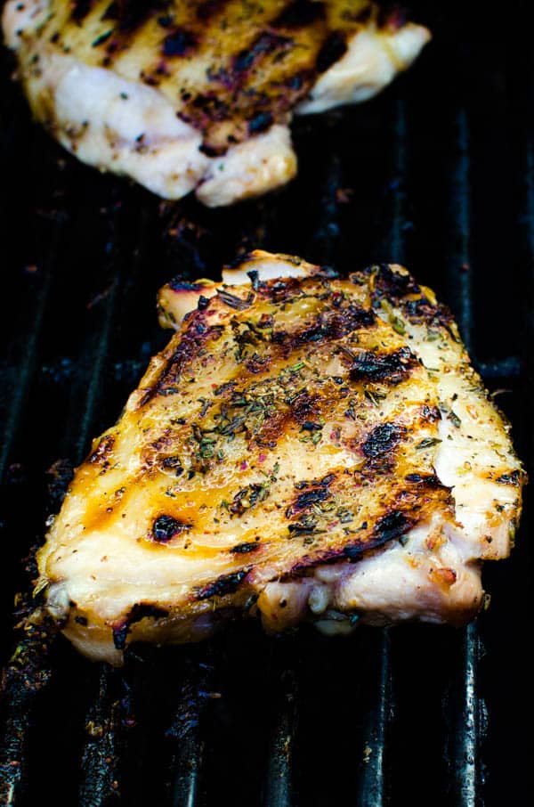 Grilled chicken thighs with spice rub on the grill.