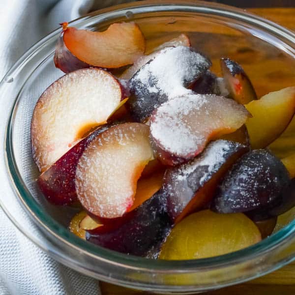 plums in a bowl with sugar