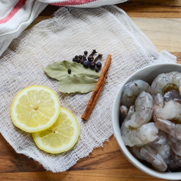 lemon slices, bay leaves, cinnamon and peppercorns with shrimp.
