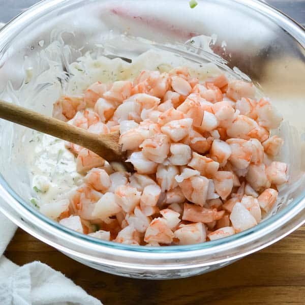 chopped shrimp in a bowl with a wooden spoon.