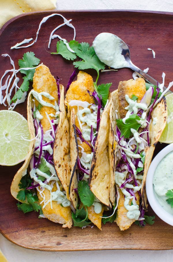 Crispy Baked Fish Tacos on a platter with lime.