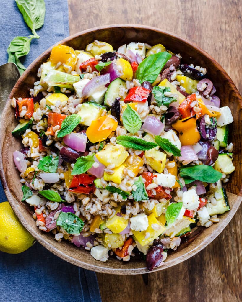 A bowl of grilled vegtable salad with farro and feta cheese.
