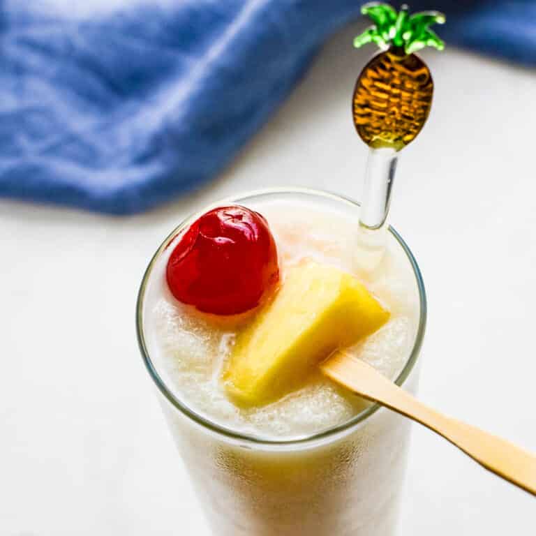 pina colada in a glass with a pineapple garnish.