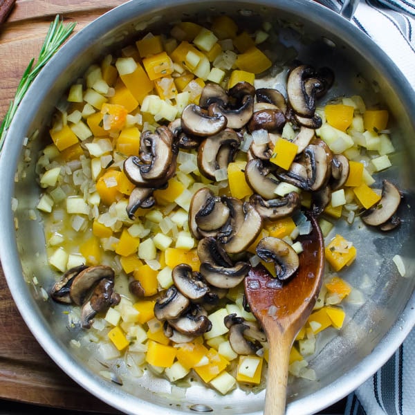 adding mushrooms to pan with spoon.