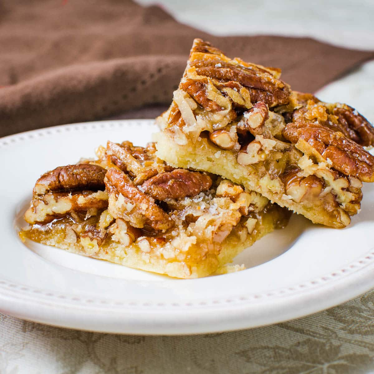 Coconut pecan bars cut into squares and served on a white plate.