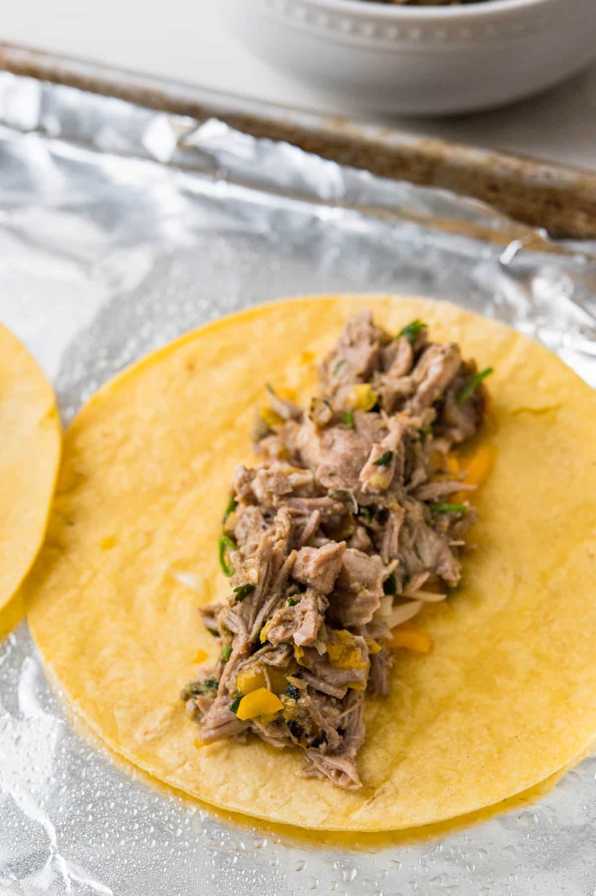 adding pulled pork to the tortilla.