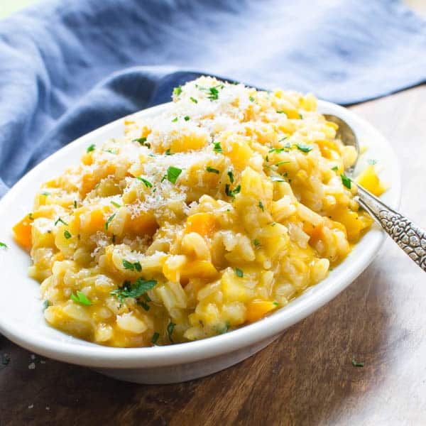  Autumn Squash Risotto with Parmigiano Reggiano on a serving dish with spoon