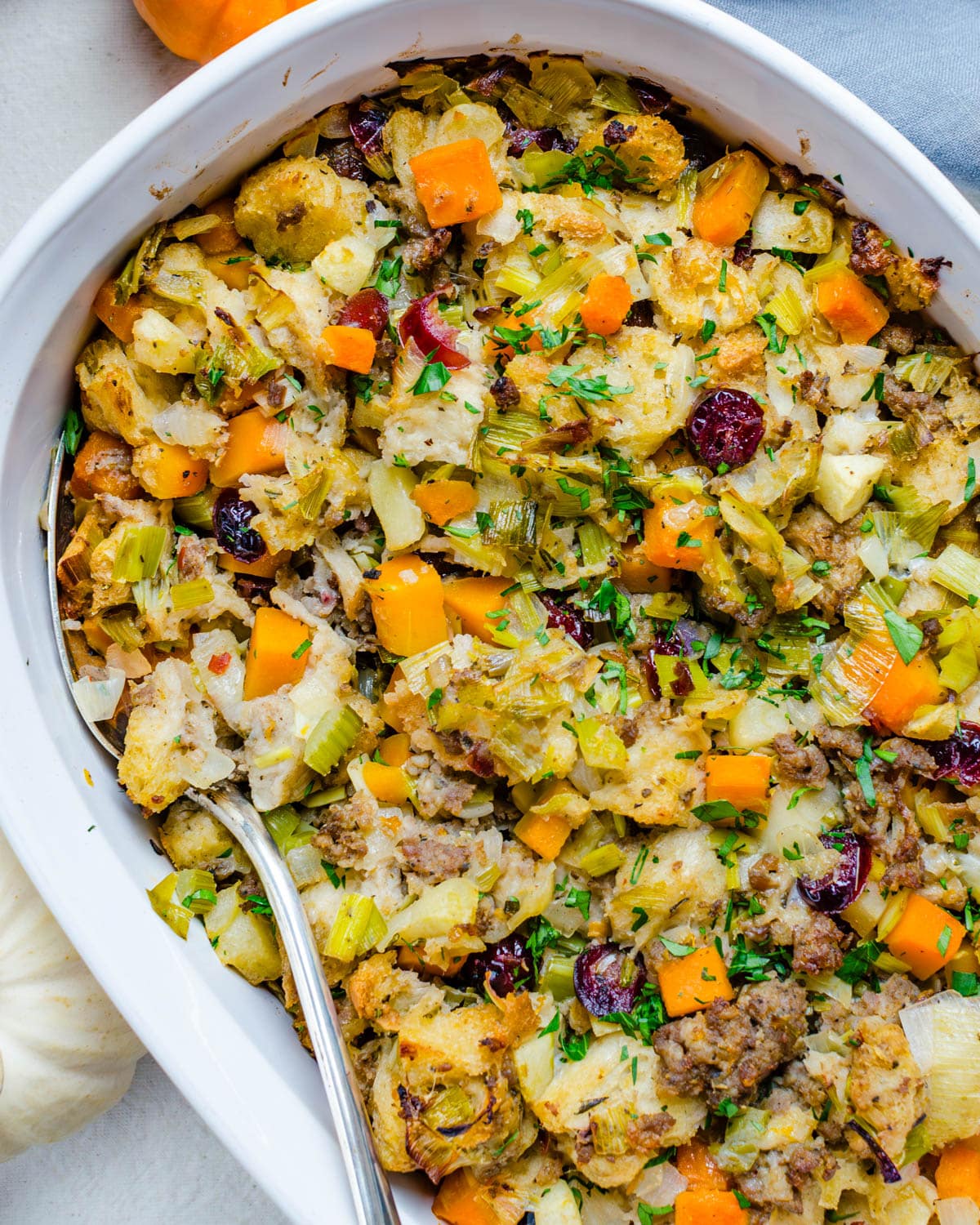 Sausage Apple Stuffing with Butternut squash in a casserole dish.