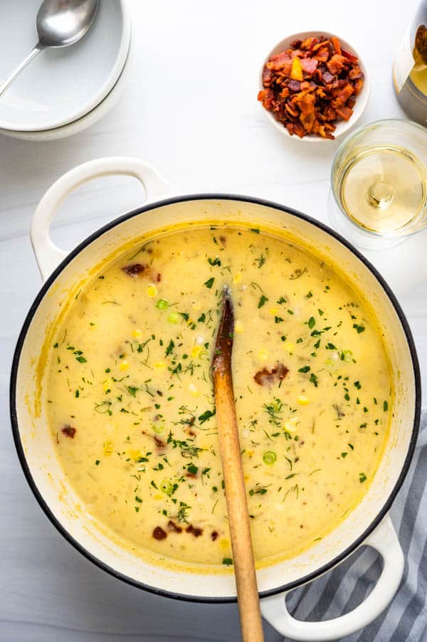 Garnish the sweet corn chowder with bacon and fresh herbs.
