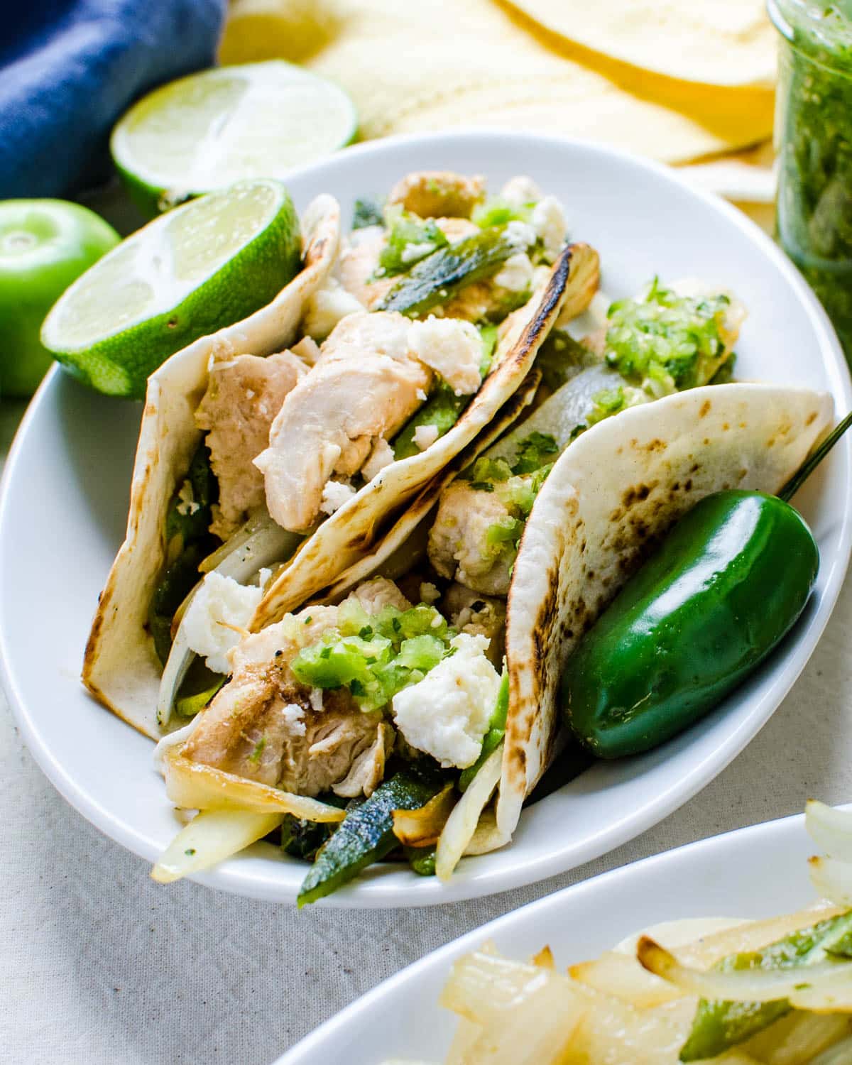 chicken soft tacos with poblano peppers and onions and tomatillo salsa.