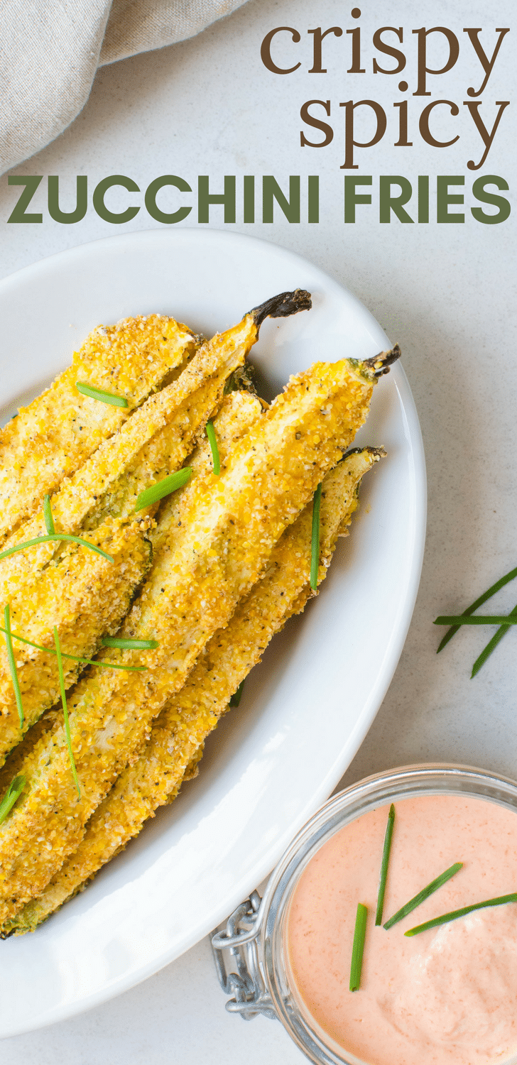 This healthier oven-baked zucchini recipe is quick and easy to make. Crispy Spicy Zucchini Fries are a delicious snack, appetizer or side dish. A gluten-free cornmeal crust and sweet pepper aioli for dipping will have even the pickiest eaters devouring their vegetables. #zucchini #squash #appetizer #snacks #sidedish #ovenfries #healthierfries #fries #glutenfree #cornmeal #eggwhites #vegetariansnacks #vegetarianappetizer #glutenfreesuperbowlsnacks #pickyeaters #easybakedfries #bakedfriesrecipe