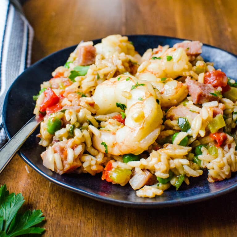 A serving of jambalaya with a shrimp on top.