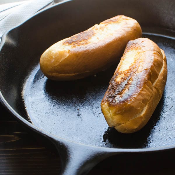 browning hot dog buns in a cast iron skillet