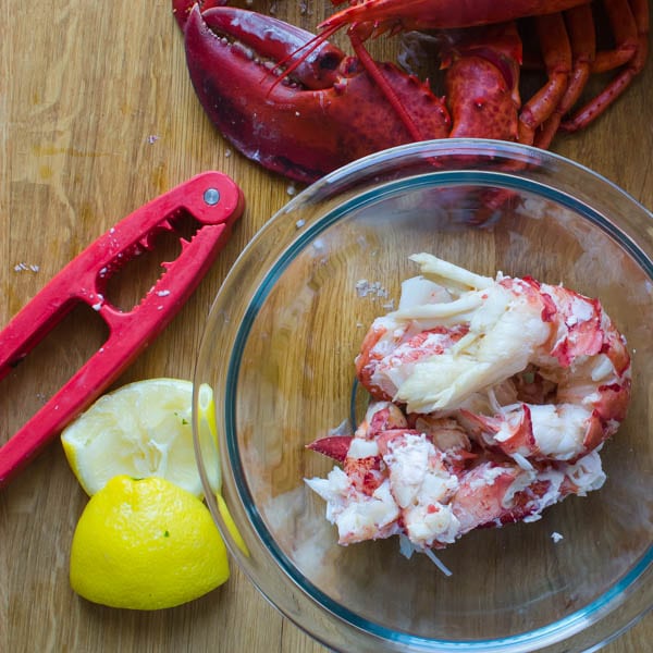 lobster meat in a bowl with lobster crackers and lemon