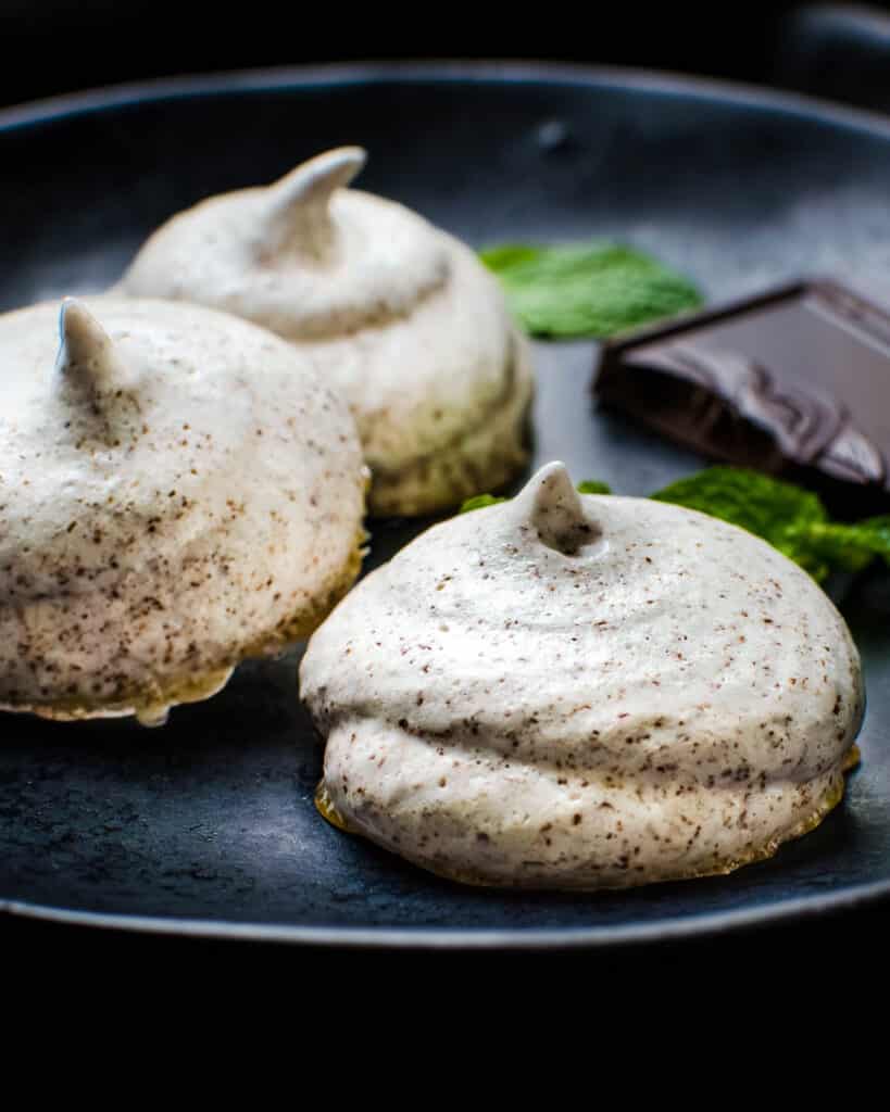 Serving chocolate mint meringue cookies on a plate.