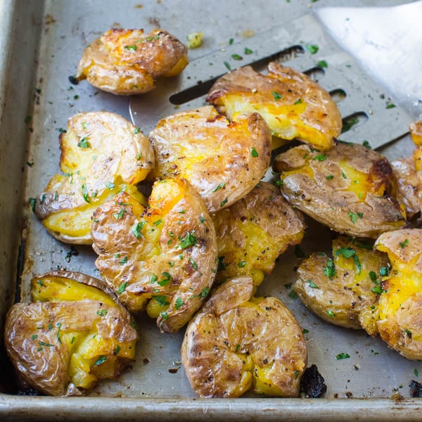 flipping roasted potatoes on a sheet pan.