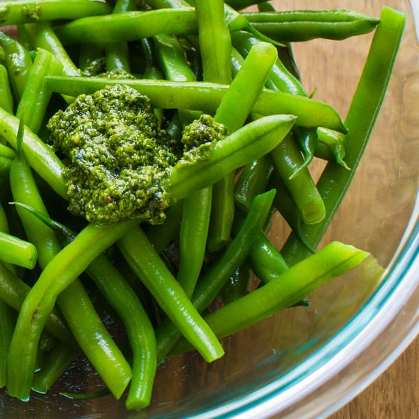 pesto spooned into green beans.