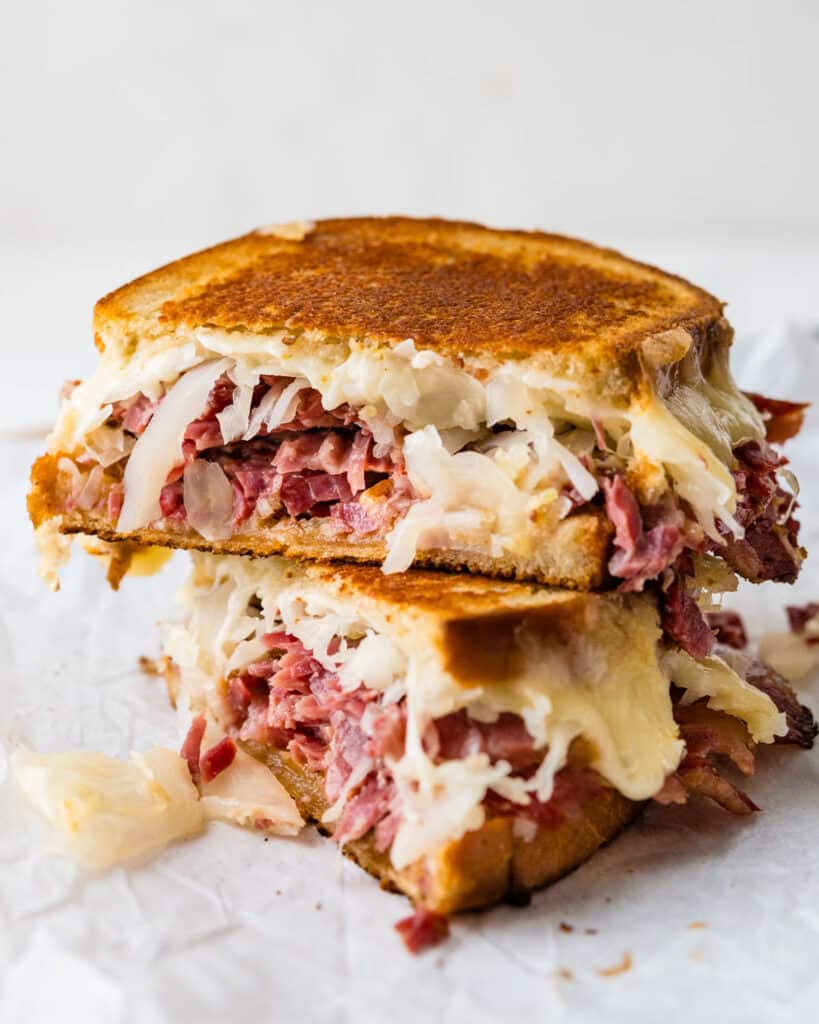 A corned beef Reuben sandwich sliced and stacked.