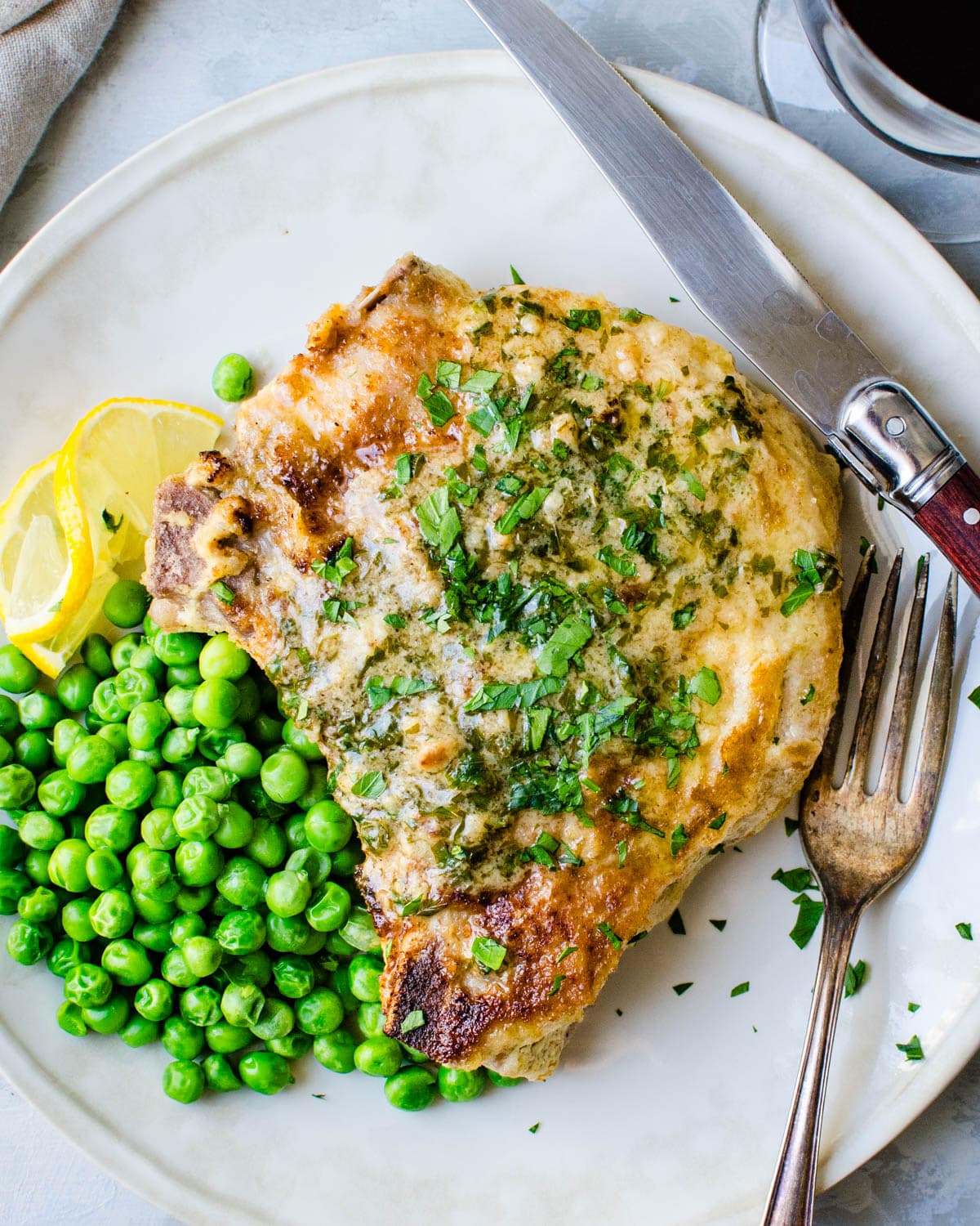 Serving pork chops and pan gravy with green peas.