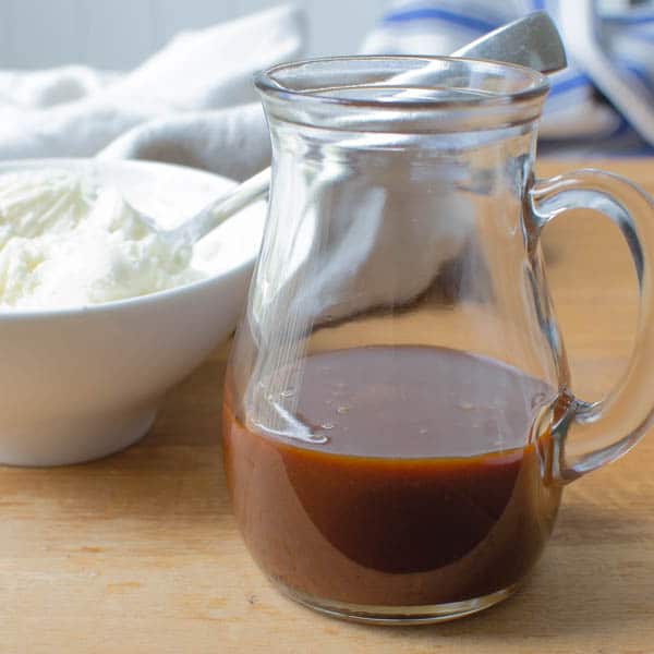 caramel sauce in a pitcher and cream cheese frosting in a bowl.