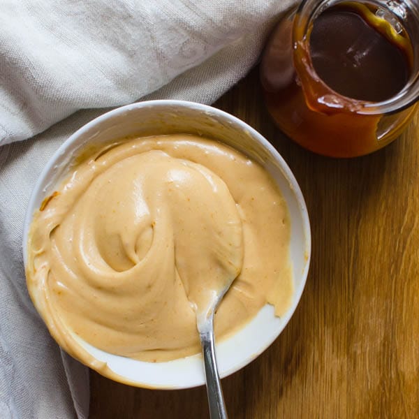 mixing the caramel cream cheese frosting in a bowl.