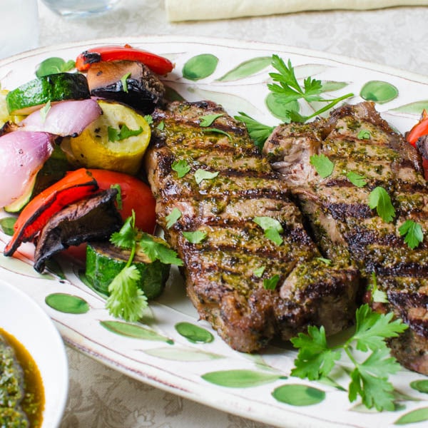 Grilled Chermoula Marinated Strip Steaks with vegetables on a platter.