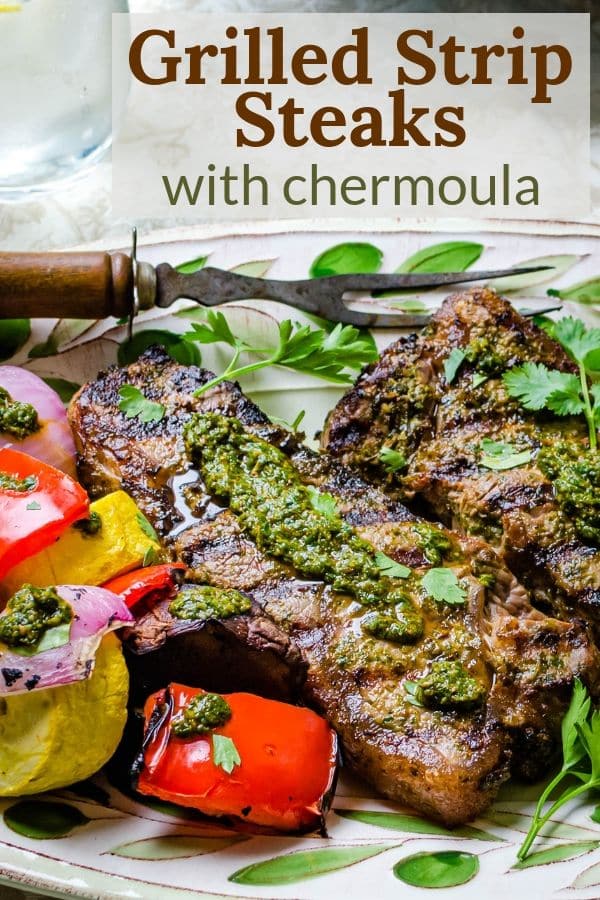 photo of grilled strip steaks with chermoula on a platter.