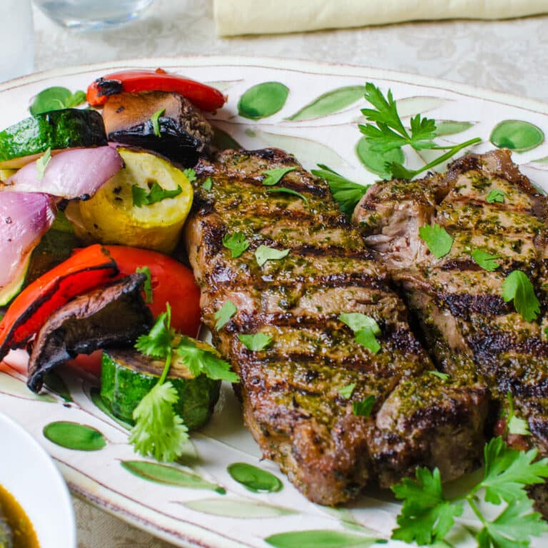 chermoula marinated strip steaks with grilled vegetables.
