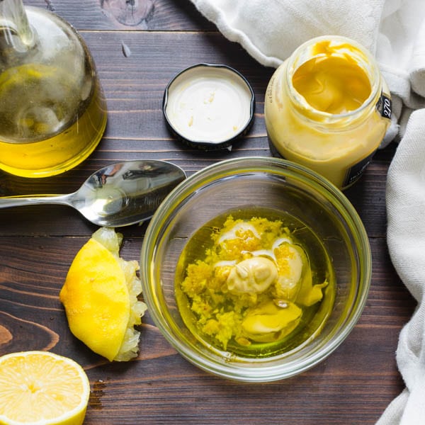 mustard, lemon, garlic and olive oil in a bowl for an easy vinaigrette recipe.