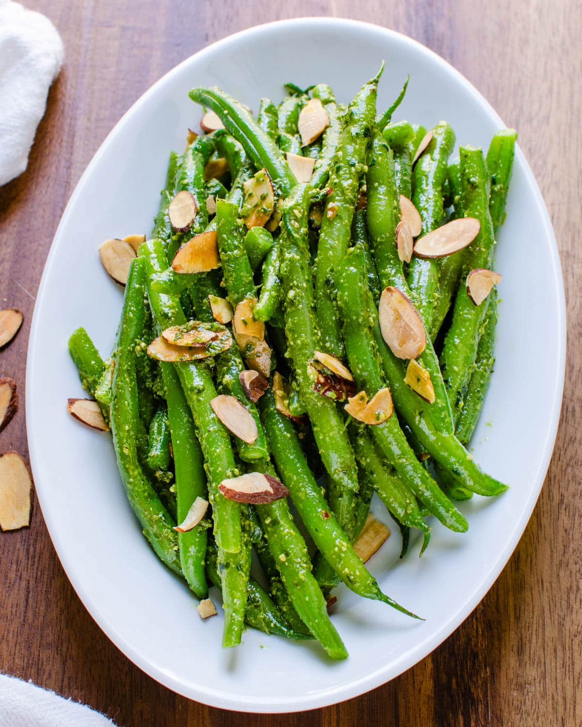 A serving dish with Italian green beans and sliced almonds.