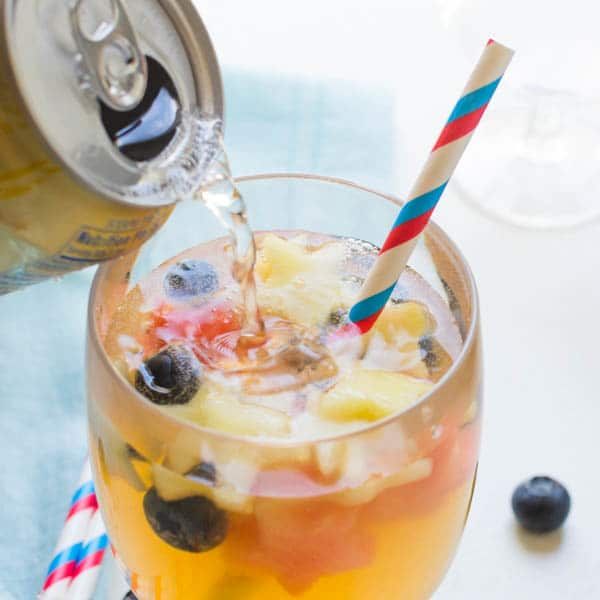 topping off sangria with sparkling water.
