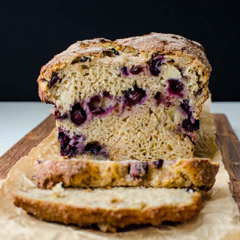 Slicing into a loaf of banana blueberry bread