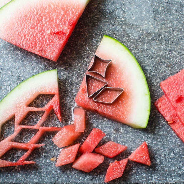 using cutters to cut watermelon into shapes.