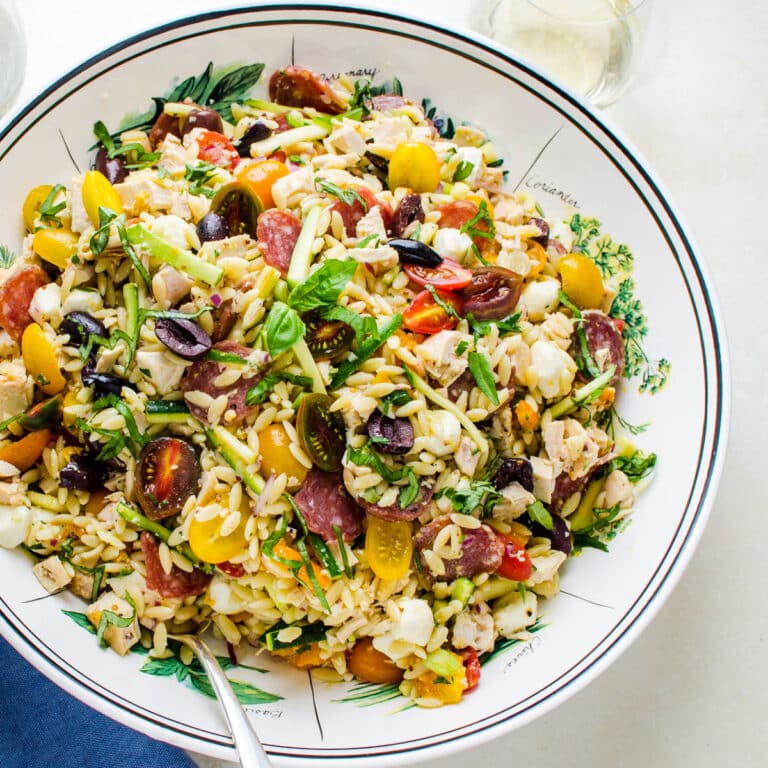 A serving bowl of orzo salad.
