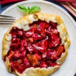 Strawberry rhubarb galette on a white plate.