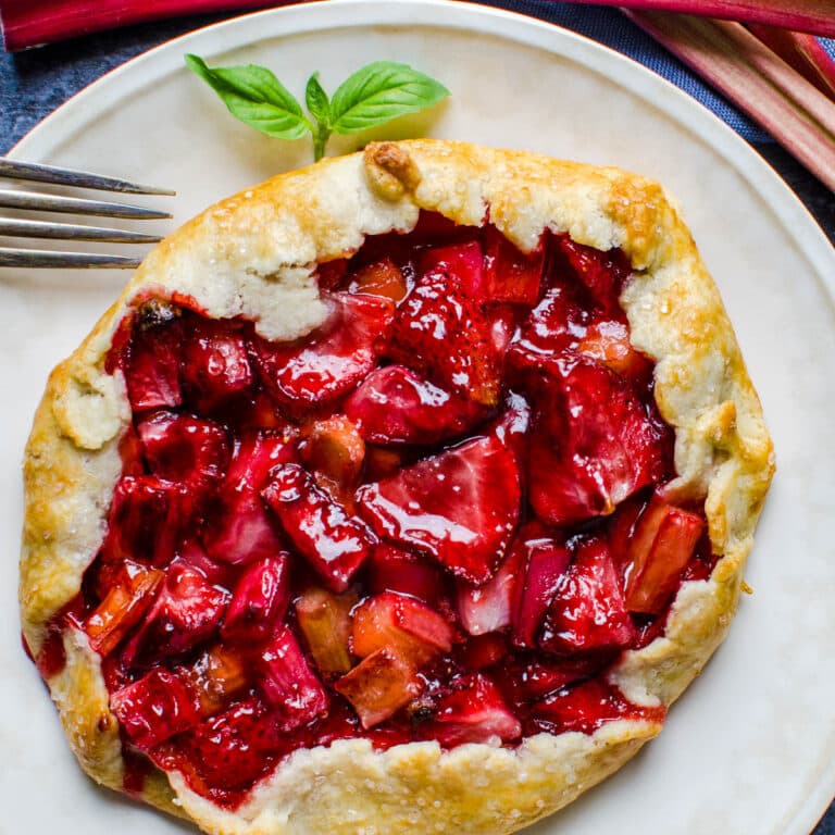Strawberry rhubarb galette on a white plate.