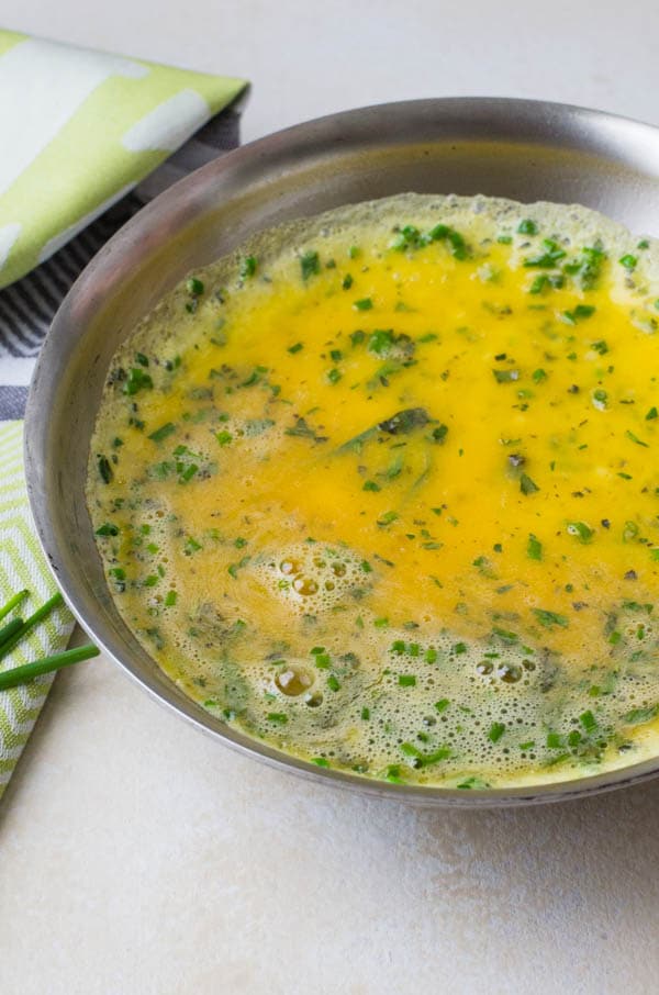 cooking herb omelette in a skillet.
