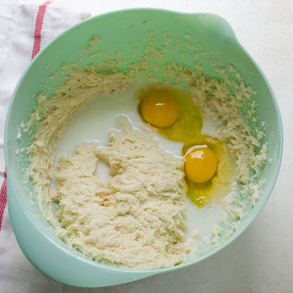 mixing batter with eggs and milk.