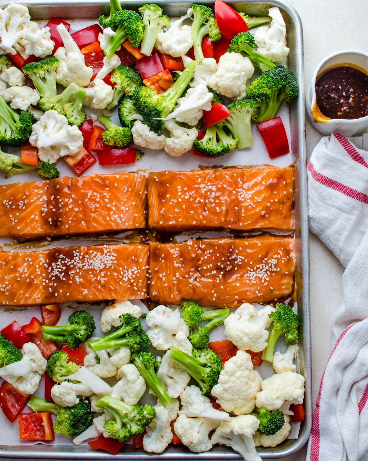 Arranging the vegetables and salmon on a sheet pan.