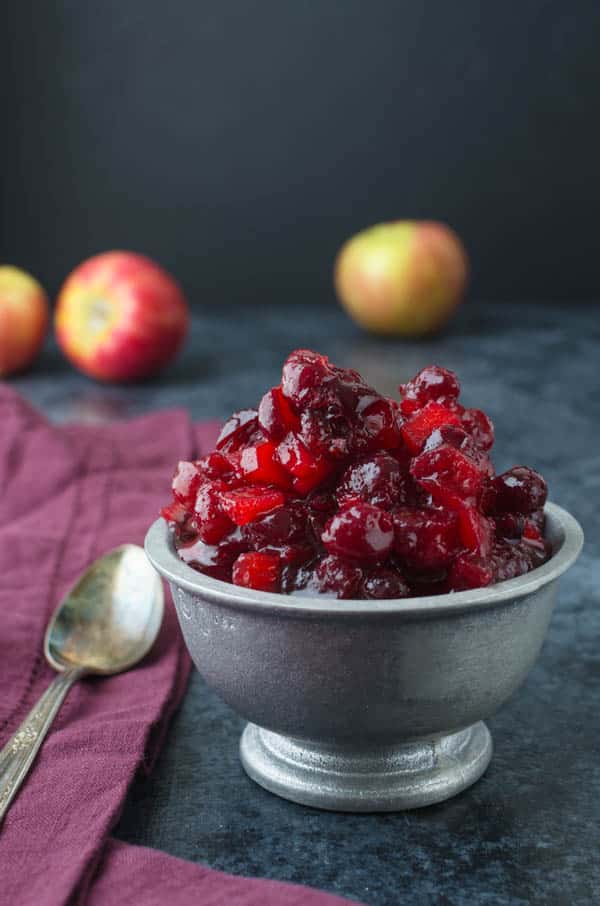 Serving Thanksgiving cranberry sauce in a bowl with spoon.